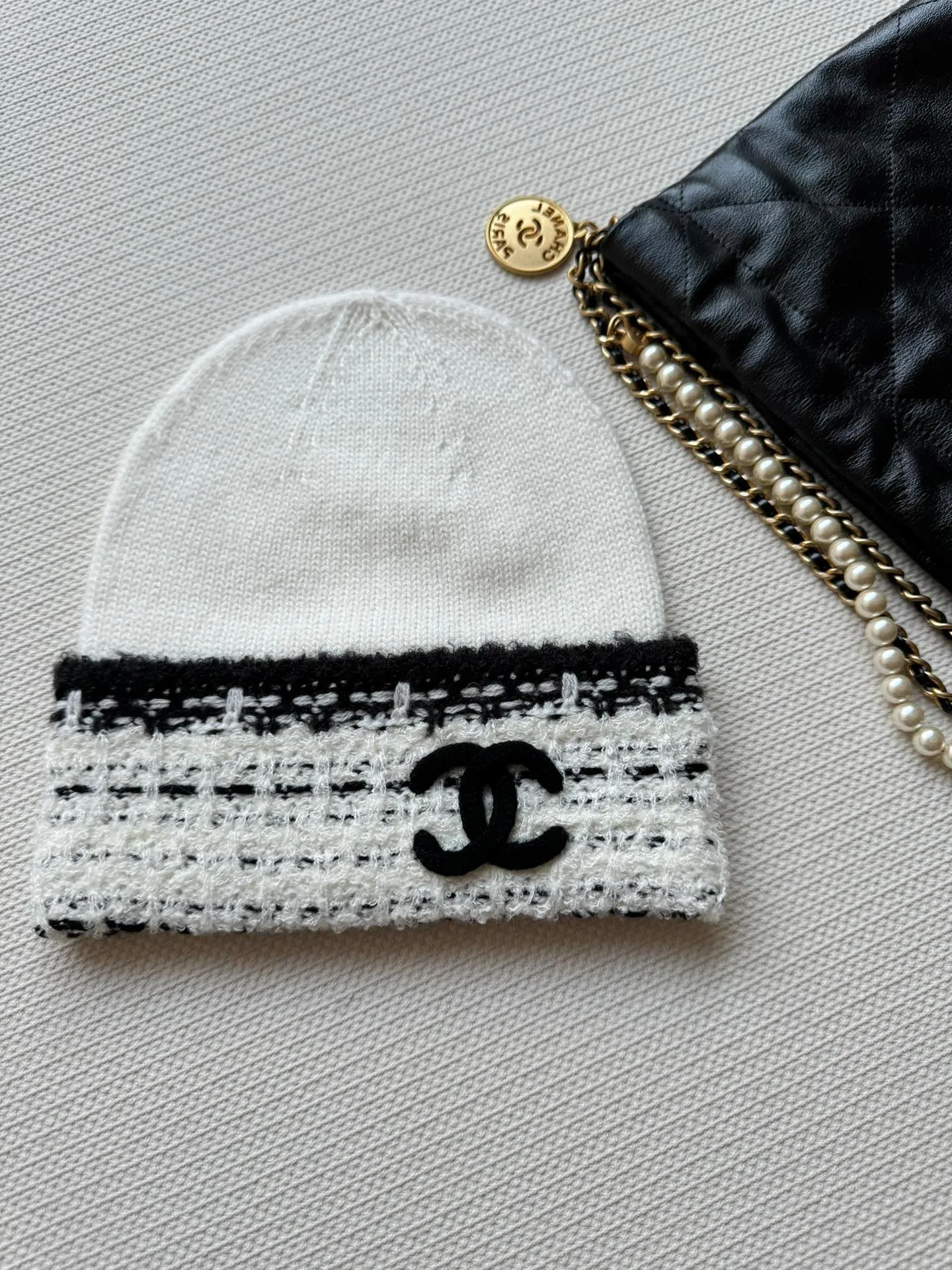 P400 is new! Chanel (Chanel) cuffed logo wool knitted hat is made of wool blended material with 7-needle plucking technology. The surface of the fabric has three-dimensional textures, a sense of layering, and a concave and convex grid texture. After the weaving is completed, the logo is hand-picked. The classic black and white color scheme shows elegance and creates a sense of atmosphere. Wear it casually to create a simple and fashionable feeling and immediately enhance the overall look.